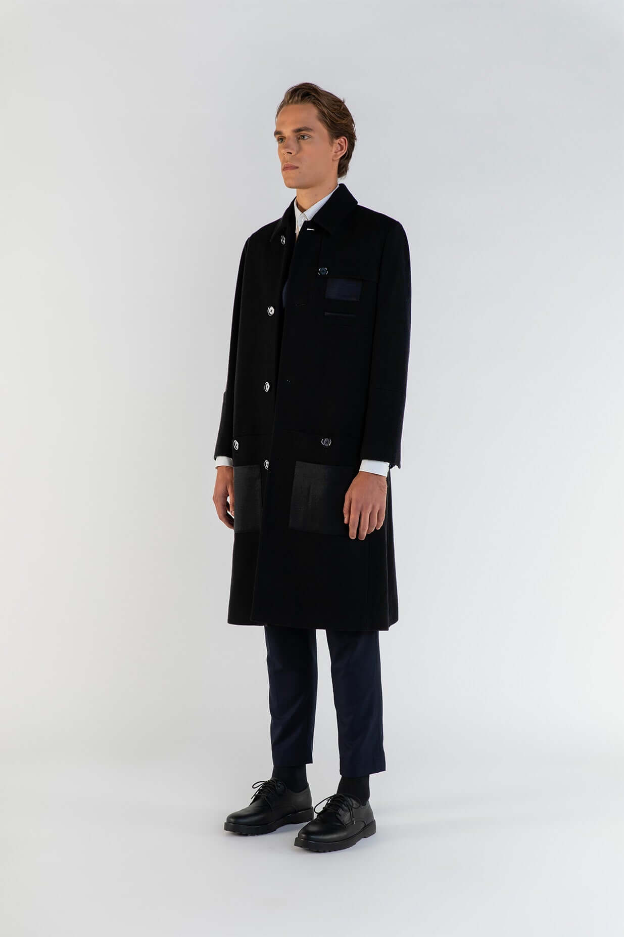 LE MANTEAU NOIR EN LAINE & CACHEMIRE porté par un homme, mettant en valeur son élégance et son confort.