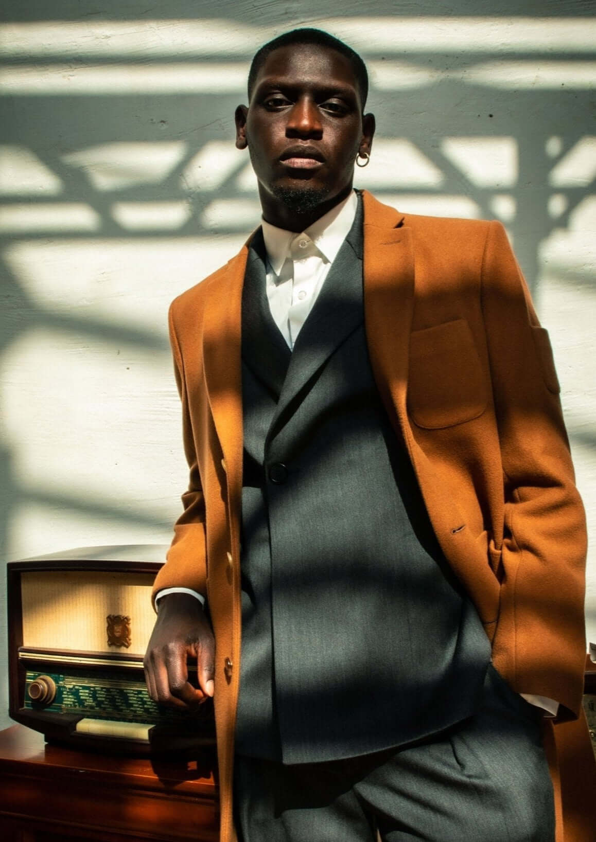 LE MANTEAU CAMEL EN LAINE & CACHEMIRE porté avec un costume stylé, créant une élégance intemporelle.