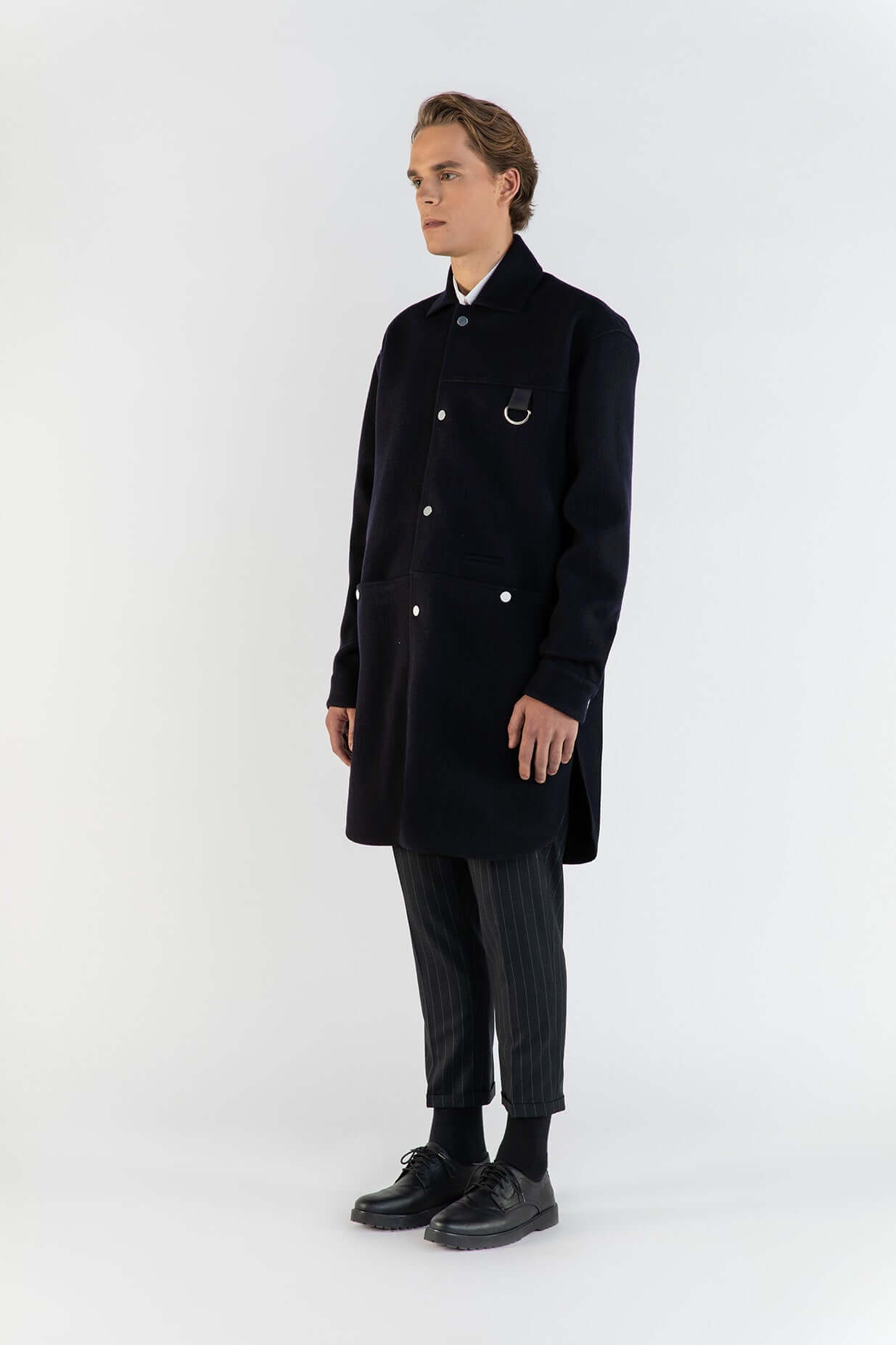 Homme portant LA SURCHEMISE BLEU EN LAINE avec poches, style sophistiqué et matériaux en laine épaisse.