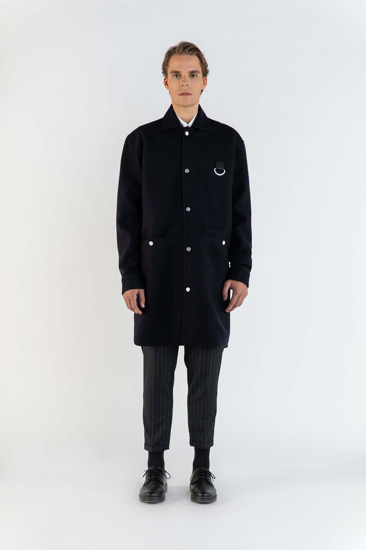 Modèle portant la surchemise bleu en laine, pièce élégante avec poches et design sophistiqué.