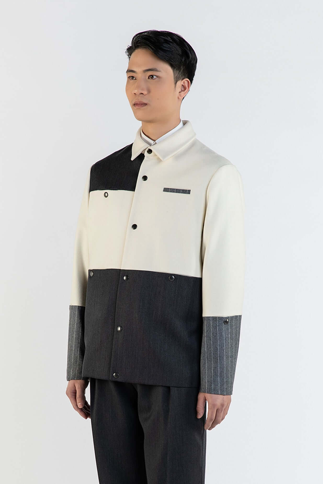 LA VESTE COACH BLANCHE & GRISE EN LAINE & CACHEMIRE portée par un homme, vue de face, sur fond blanc.