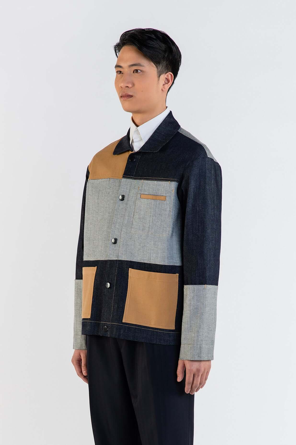 Homme portant LA VESTE WORKER EN COTON avec patchworks artistiques et textures variées.