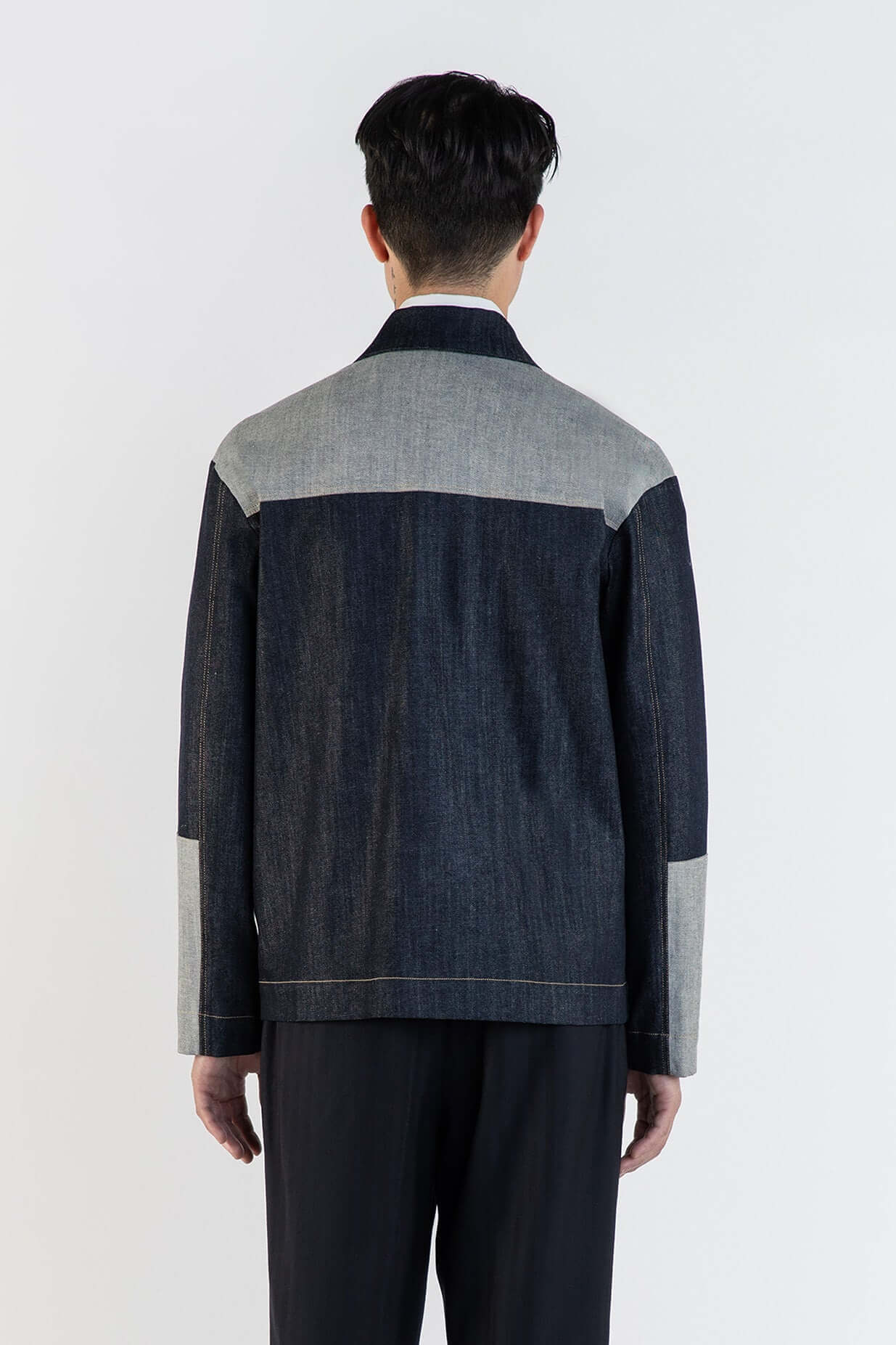 Homme portant LA VESTE WORKER EN COTON, vue arrière, mettant en avant la texture et le design patchwork.
